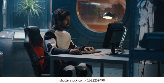 Medium Shot Of A Male Astronaut Working On A Computer