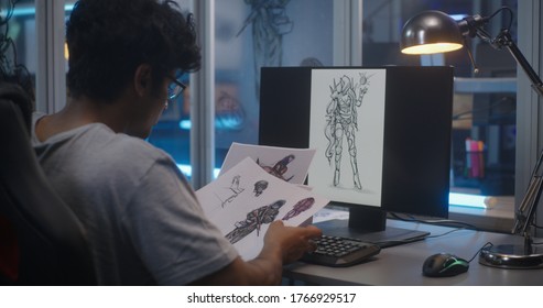 Medium Shot Of A Male Graphic Designer Sorting Concept Art For Video Game