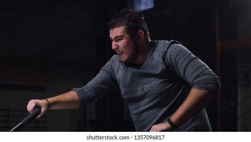 Medium Shot Of An Overweight Young Man Doing An Intense Workout On An Exercise Bike