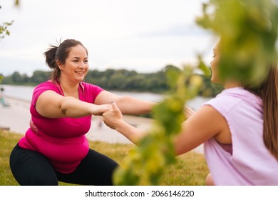 Medium Shot Of Professional Fitness Female Trainer Giving Personal Training To Overweight Young Woman Outdoor In Summer Day. Instructor Help Fat Woman Lose Weight Outside Doing Squats Outside.