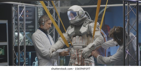 Medium shot of scientists attaching anti-gravity bands to an astronaut - Powered by Shutterstock