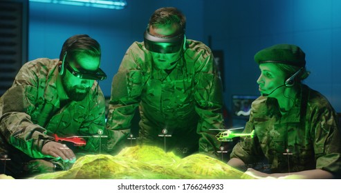 Medium shot of soldiers discussing military strategy with holographic landscape display - Powered by Shutterstock