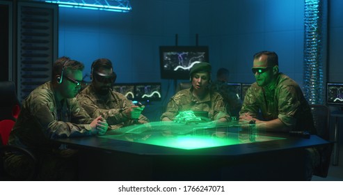 Medium Shot Of Soldiers Remote Controlling Unmanned Ground Vehicle In A Military Base Using Holographic Table Technology, Futuristic Concept