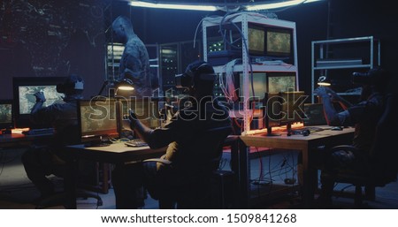Medium shot of soldiers using VR technology while sitting at their desks