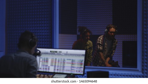 Medium Shot Of Two Foley Artists And Sound Engineer Working In Studio