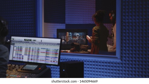 Medium Shot Of Two Foley Artists And Sound Engineer Working In Studio