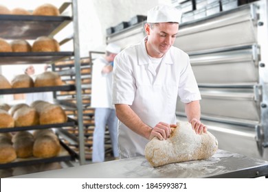 A medium shot of a young baker kneading bread dough in a bakery. - Powered by Shutterstock