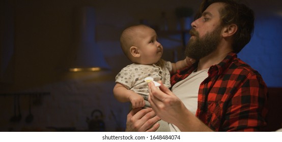 Medium Shot Of A Young Father Feeding Then Handing His Baby Over To Mother At Night