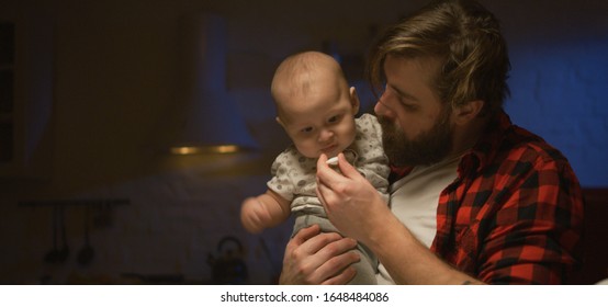 Medium Shot Of A Young Father Feeding His Baby At Night