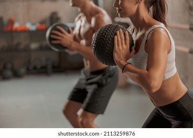 Medium Shot Of Young Woman And Man In Workout Clothes Training Together With Balls In Gym Club