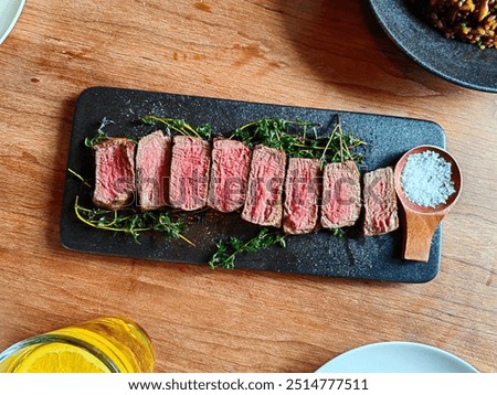 Medium well cooked dish of Beef background on a wooden table and set of fork, knife and punkin soup. Warm pumpkin stew with potato and beef meat.