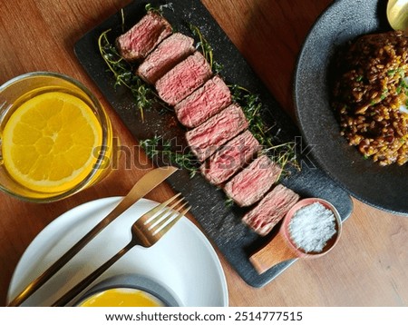 Medium well cooked dish of Beef background on a wooden table and set of fork, knife and punkin soup. Warm pumpkin stew with potato and beef meat.