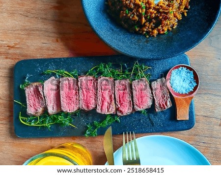 Medium well cooked dish of Beef background on a wooden table and set of fork, knife and punkin soup. Warm pumpkin stew with potato and beef meat, comfort autumn dinner balanced food.