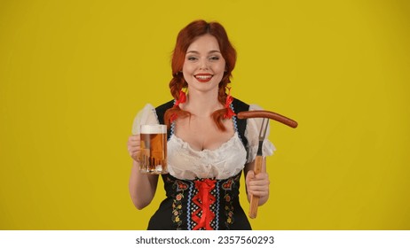 Medium yellow background isolated shot of a young German woman, waitress, wearing a traditional costume, holding a wurst and a glass of beer and laughing.