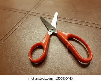 Medium-sized scissors and a red handle and Put on a brown cloth