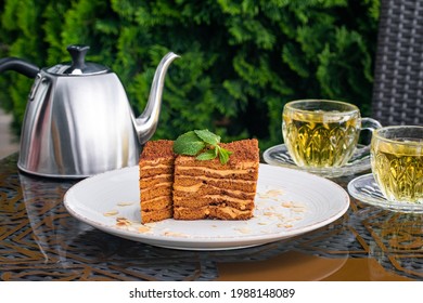 Medovik Cake Covered With Crumbs, Two Cups With Mint Tea And Steel Kettle On Table In Summer Cafe. Tea Drinking Concept, British Culture. Still Life. Russian Cuisine, Breakfast. Selective Focus.