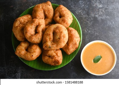 Medu Vada With Tiffin Sambar Coconut Chutney In Banana Leaf Plate On Dark Black Background Savoury Fried Snack Of Kerala Tamil Nadu South India. Top View Of Indian Veg Breakfast Food.