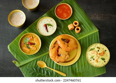 Medu Vada with tiffin sambar coconut chutney in banana leaf background. Savory fried tea time snack of Kerala Tamil Nadu South India. Top view of Indian veg breakfast food. - Shutterstock ID 2247460761