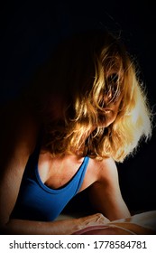 Meerkerk, The Netherlands- July 17 2020: Intense And Powerful Colour Low Key Portrait Of A Woman With Wild Blond Hair And Dark Black Background