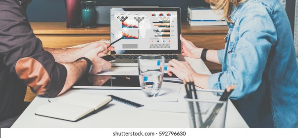 Meet one-on-one. Teamwork. Businesswoman and businessman sitting at table and looking at graphs, charts and diagrams on computer screen. Man shows pencil on computer monitor. Students learning online. - Powered by Shutterstock