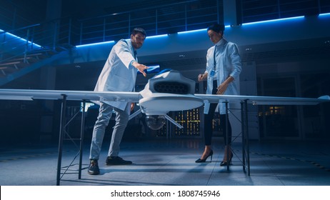 Meeting of Aerospace Engineers Working On Unmanned Aerial Vehicle / Drone Prototype. Aviation Scientists in White Coats Talking. Commercial Aerial Surveillance Aircraft in Industrial Laboratory - Shutterstock ID 1808745946