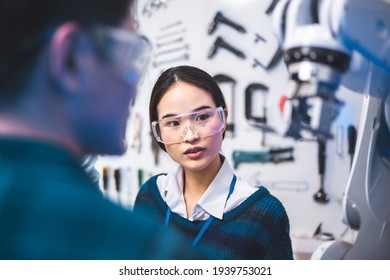 Meeting Asian Engineers Maintenance Robot Arm At Lab. They Are In A High Tech Research Laboratory With Modern Equipment. Professional Japanese Development Engineer Testing An Artificial Intelligent.