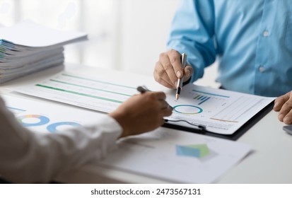 Meeting to discuss market situation analysis using financial charts in business reports. Financial planning consultant and investment portfolio analysis. - Powered by Shutterstock