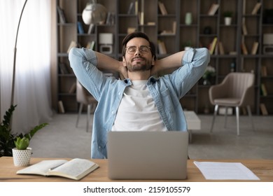 Meeting Friday. Happy Young Guy Freelancer Enjoy Calm Moment When Task Is Done Relax Rest Stretch Back Hold Hands Over Head. Serene Millennial Man Recline On Chair With Closed Eyes Take Break In Work