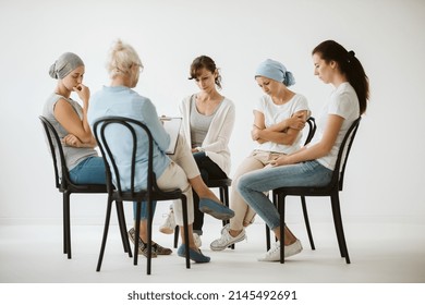 Meeting Of Group Of Women Sitting Together During Psychotherapy With Senior Counselor