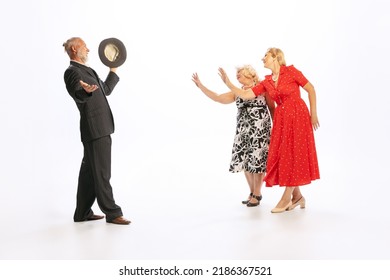 Meeting. Handsome Senior Man And Two Charming Women In Vintage Retro Style Outfits Dancing Isolated On White Background. Concept Of Relations, Family, 1960s American Fashion Style And Art.