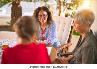 Meeting Of Middle Age Women Having Lunch And Drinking Coffee. Mature Friends Smiling Happy Using Smartphone At Home On A Sunny Day