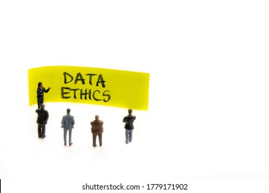 Meeting With Miniature Figurines Posed As Business People Standing Around Post-it Note With Data Ethics Handwritten Message In Background, Minimalist Abstract Concept With Focus On Text