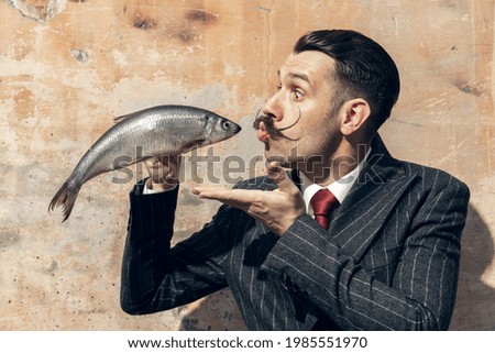 Meeting. Portrait of young male actor in the image of greatest painter Salvador Dali, artist isolated on light background. Retro style, comparison of eras, fashionable characters concept. Artwork
