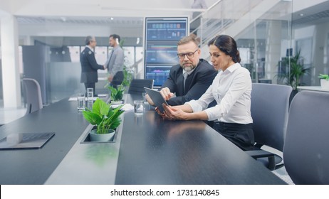 In the Meeting Room Female Executive Shows Digital Tablet Computer to Male Investor, They Discuss Statistics and Venture Investing Potential. Busy Corporate Office with Businesspeople Working - Shutterstock ID 1731140845