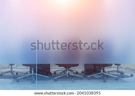 Meeting room in a modern office, with blurred glass partitions and movable chairs