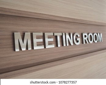 Meeting Room Sign Hanging On The Wall Wood Background Texture.
