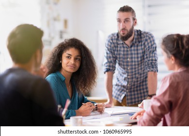 meeting at the startup office. A young man leads a multi-ethnic working group - Shutterstock ID 1060965995