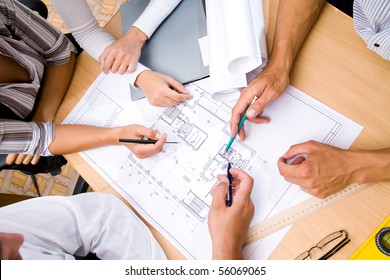 Meeting The Team Of Engineers Working On Construction Project At The Table. Only Hands.  Up View