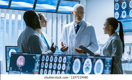 Meeting Of The Team Of Medical Scientists In The Brain Research Laboratory. Neurologists / Neuroscientists Having Analytical Discussion Surrounded By Monitors Showing CT, MRI Scans.