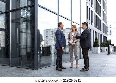 Meeting Of Three Successful Business People, Diverse Dream Team Man And Woman Outside Office Building, Greeting And Shaking Hands, Experienced Professionals Specialists In Business Suits Talking