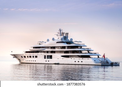 Mega yacht at anchor in a beautiful calm morning, with purple and blue tones