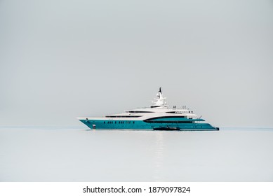 Mega yacht in a very still setting, isolated with grey background and water
