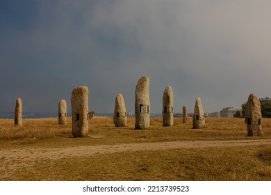 Megaliths Stone Pillars Stand Alone In A Field With Yellow Grass And Blue Sky