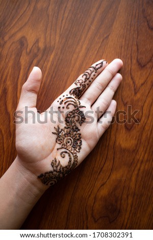 Mehandi or Mehndi design on Indian girls hand Rajasthan, India. beautiful henna Arabic designs on wedding on wooden background. popular form of body art among the women of India, Pakistan, Africa.