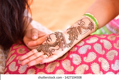 Mehndi Artist making a mehndi design bridal hands on her wedding day