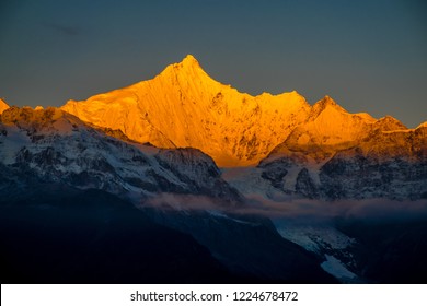 Meilixueshan - Meili Snow Mountain (Kawa Karpo) range in Deqin, Yunnan Province China. Early Dawn view of exotic mountains, dark blue atmospheric sky. Crisp white moonlit snow cliffs and glaciers.