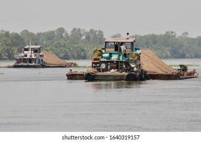 Mekong Delta / Vietnam - March 11, 2018:  Ferries On A Waterway In The Countryside Of The Mekong Delta  Transporting Sand And Gravel.