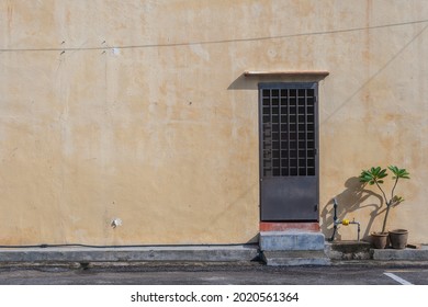 Melaka , Malaysia -  2010, A backlane view of a classic urban buildings backdoor with potted plants with shadow casted on the wall in the historical town 