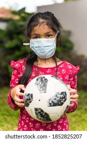 Melaka , Malaysia - Circa October 2020: A Malay Girl With A Face Mask Holding A Soccer Ball. Selective Focus