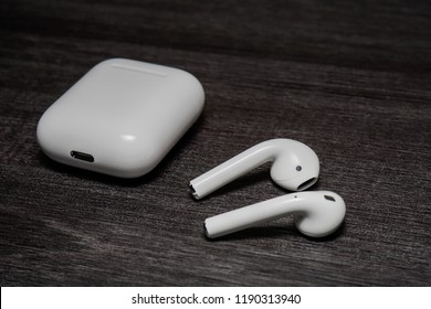 Melaka, Malaysia - Circa September, 2018: Apple AirPods wireless Bluetooth headphones and charging case for Apple iPhone on a black background. New Apple Earpods Airpods and box.